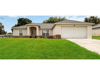 Charming single-story home with well-maintained lawn and inviting front entrance, and two-car garage at 630 Park Valley Cir, Minneola, FL 34715