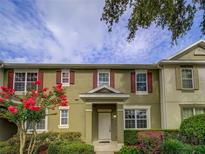 Charming townhome featuring red shutters, a well manicured front yard, and a welcoming entrance at 7462 Bentonshire Ave, Windermere, FL 34786