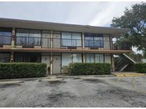 Two-story exterior showing balconies, walkway and parking, on a sunny day at 7900 S Orange Blossom Trl, Orlando, FL 32809