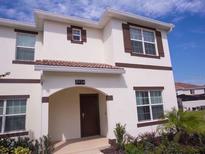 Beautiful two story home showcasing a modern entrance and well maintained landscaping at 8934 Stinger Dr, Davenport, FL 33896