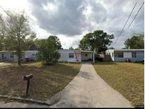 Modest single story home featuring a paved driveway and an expansive front lawn area at 920 Hacienda Ct, Orlando, FL 32808