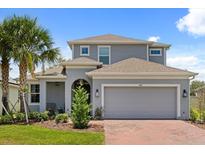 Charming two-story home with a well-manicured lawn and a spacious two-car garage with brick-paved driveway at 922 Grazie Loop, Davenport, FL 33837