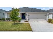 Charming single-story home featuring a well-maintained lawn and a two-car garage at 1159 Mountain Flower Ln, Davenport, FL 33837