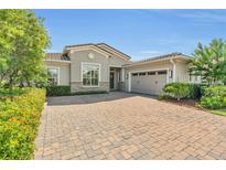 Charming single-Gathering home showcases lush landscaping and a brick paver driveway at 13232 Alderley Dr, Orlando, FL 32832
