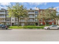 Stately condominium building featuring multiple balconies and manicured landscaping at 1400 Celebration Ave # 203, Celebration, FL 34747