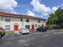 Two story condominium with a red tiled roof and reserved parking spaces on a sunny day at 1635 Little Falls Cir, Orlando, FL 32807