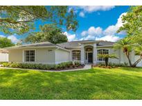 Charming single story home featuring a well-manicured lawn, garden beds, and a walkway to the front door at 2024 Flaming Arrow Ct, Fern Park, FL 32730