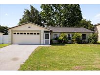Charming single-story home with a well-maintained lawn and attached two-car garage at 303 Mariana Way, Kissimmee, FL 34758