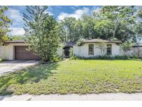 Charming single-story home with a brown garage door and mature landscaping in the front yard at 380 Violet Dell Dr, Casselberry, FL 32707