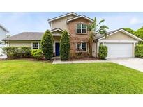 Charming two-story home with brick accents, manicured lawn, and a blue front door at 4478 Yachtmans Ct, Orlando, FL 32812