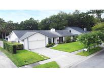 Charming single-story home with a well-manicured lawn, neutral paint, a two-car garage, and a beautiful gray brick paver driveway at 448 Stonewood Ln, Maitland, FL 32751