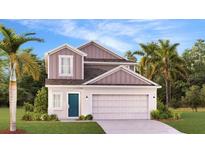 Charming two-story home boasts a welcoming blue front door, well-manicured lawn, and attached two-car garage at 5687 Portico Pl, Kissimmee, FL 34758
