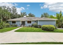 Charming single-story home with a well-manicured lawn, lush landscaping, and a welcoming entrance at 5836 Spruce Creek Woods Dr, Port Orange, FL 32127
