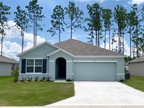 Charming one-story home with a well-maintained lawn and an attached two car garage at 613 Hickory Course Loop, Ocala, FL 34472