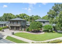 Stunning exterior showcasing a manicured lawn and a two-story home with balcony and dual garage at 640 S Lake Formosa Dr, Orlando, FL 32803