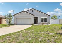 Charming one-story home with a well-manicured lawn, attached garage, and neutral-colored exterior at 785 Orchid Grove Blvd, Davenport, FL 33837