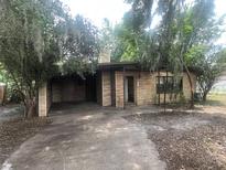 Charming home featuring a unique stone facade and inviting driveway, surrounded by lush trees at 4250 Lake Ave, Kissimmee, FL 34746