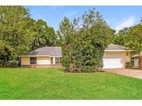 Charming single story home with a well-manicured lawn and mature trees at 10448 Sw 74Th Ct, Ocala, FL 34476