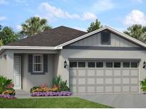 Charming single-story home with a two-car garage, neutral paint, a well-manicured lawn and a garden bed with purple flowers at 1210 Atlantic Ave, Fruitland Park, FL 34731