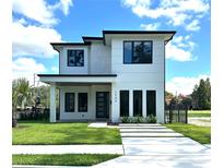 Modern two-story home boasting a clean white facade, black trim, manicured lawn, and contemporary landscaping at 1733 Harmon Ave, Winter Park, FL 32789