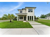 Modern two-story home with a well-manicured lawn, minimalist landscaping, and contrasting dark trim at 1733 Harmon Ave, Winter Park, FL 32789