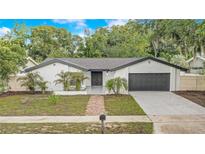 Charming one-story home featuring a well-manicured front yard, brick pathway, and a neatly painted garage door at 1921 Heathwood Dr, Winter Park, FL 32792