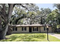 Charming single-story home with a well-manicured lawn and mature trees providing shade at 2342 Alice Ave, Eustis, FL 32726
