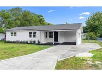 Charming single-story home with a modern white exterior, covered entry, and well-maintained lawn at 36 Morning Glory Dr, Debary, FL 32713