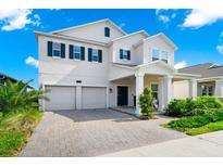 Charming two-story home featuring a two-car garage, blue shutters, and a brick driveway at 4908 Lotta Ct, St Cloud, FL 34772