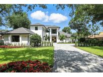 Stunning two-story home featuring manicured lawn, vibrant flower beds and a paved driveway leading to the grand entrance at 5074 Isleworth Country Club Dr, Windermere, FL 34786