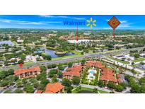 Aerial view of the condo community with a lush landscape, lake, and close proximity to Walmart at 5566 Metrowest Blvd # 10, Orlando, FL 32811