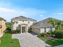 Charming two-story home with lush landscaping and a brick paver driveway at 5819 Covington Cove Way, Orlando, FL 32829