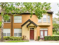 Inviting exterior of a two-story townhome featuring a quaint, covered entryway and well-maintained landscaping at 6384 Raleigh St # 2214, Orlando, FL 32835