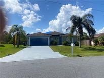 Charming single-story home featuring a well-maintained lawn, long driveway and a two-car garage at 739 Parrot Ct, Poinciana, FL 34759