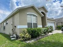 Inviting home with well-maintained landscaping and a large window allowing for plenty of natural light at 2546 Oneida Loop, Kissimmee, FL 34747