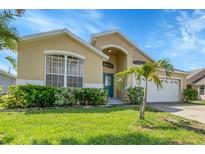 Charming single-story home with a well-manicured lawn and a welcoming blue front door at 2546 Oneida Loop, Kissimmee, FL 34747