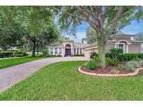 Charming home featuring a brick driveway, well-manicured lawn and mature trees at 2579 Woodside Ridge Dr, Apopka, FL 32712