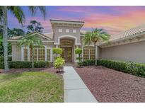 Beautiful home exterior with lush landscaping, palm trees, and inviting front entry at sunset at 336 Highcroft Ct, Lake Mary, FL 32746