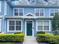 Charming two-story condo featuring a green front door, white trim, and manicured landscaping at 4011 Venetian Bay Village # 104, Kissimmee, FL 34741