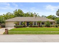 Charming single-story home featuring manicured landscaping and a brick facade with a welcoming front lawn at 548 Timber Ridge Dr, Longwood, FL 32779