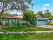 Charming single-story home featuring lush landscaping and a two-car garage at 9543 Buxton, Orlando, FL 32817