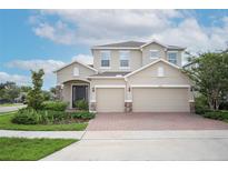 Charming two-story home featuring a three car garage, well-maintained landscaping, and brick paved driveway at 1222 Castlevecchio Loop, Orlando, FL 32825