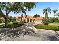 Stunning exterior showcasing a well-manicured lawn, terracotta roof, palm trees, and a circular driveway at 1274 Prince Ct, Lake Mary, FL 32746
