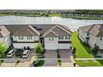 Beautiful multi-Gathering home overlooking a serene lake featuring a brick driveway and solar panels at 15577 Willow Arbor Cir, Orlando, FL 32824