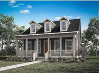 Charming cottage-style home featuring a welcoming front porch and three dormer windows, complemented by lush landscaping at 1993 Beach Ter, Celebration, FL 34747