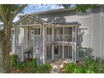 Inviting exterior view of condo featuring gray siding, stairs, and a small balcony at 2206 Stonington Ave # 2206, Orlando, FL 32817