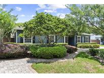Charming single-story home featuring professional landscaping with mature trees and a brick walkway leading to the entrance at 2312 S Summerlin Ave, Orlando, FL 32806