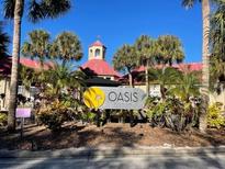 Beautiful community entrance with lush landscaping, towering palm trees, and well-maintained signage at 236 Afton Sq # 207, Altamonte Springs, FL 32714