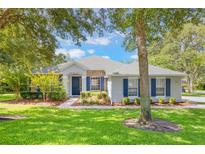 Charming home with manicured lawn, blue shutters, and brick accents creating a welcoming exterior at 2782 Cedar Knoll Dr, Apopka, FL 32712