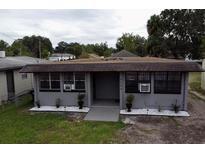 Charming one-story home featuring gray paint, window security bars, and landscaping at 4204 Columbia St, Orlando, FL 32811